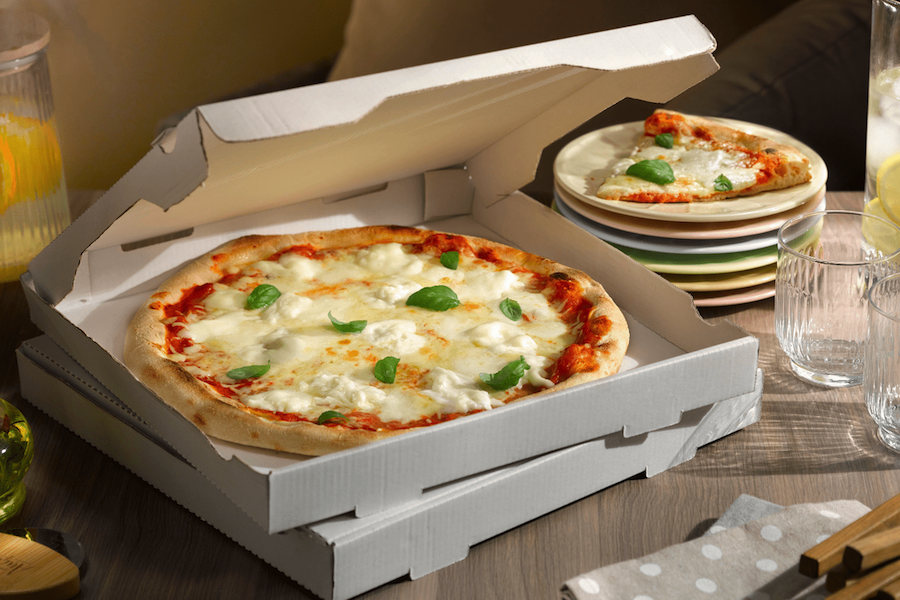 Une pizza artisanale présentée dans une boîte pour un service en camping