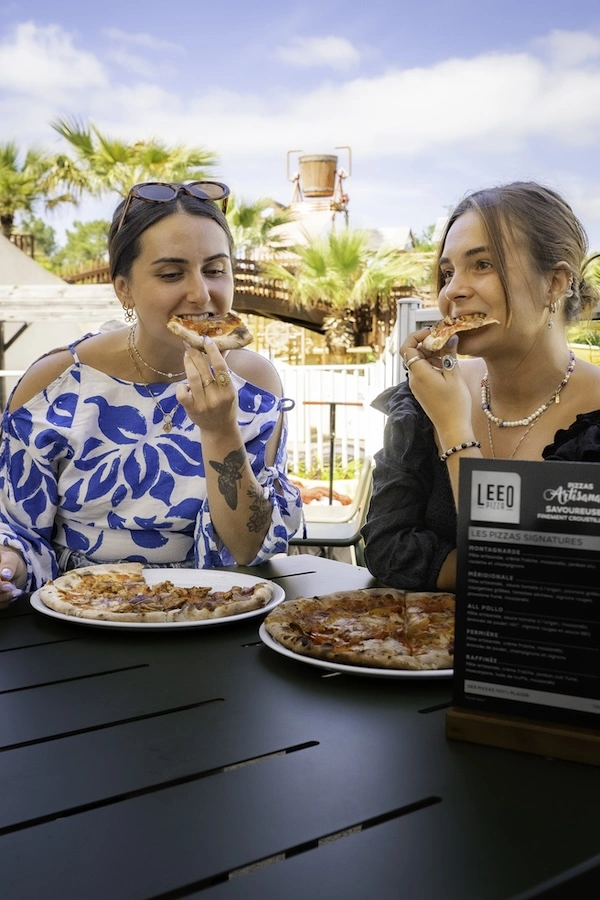 Deux vacancières dans un camping en train de déguster une pizza Leeo Pizza