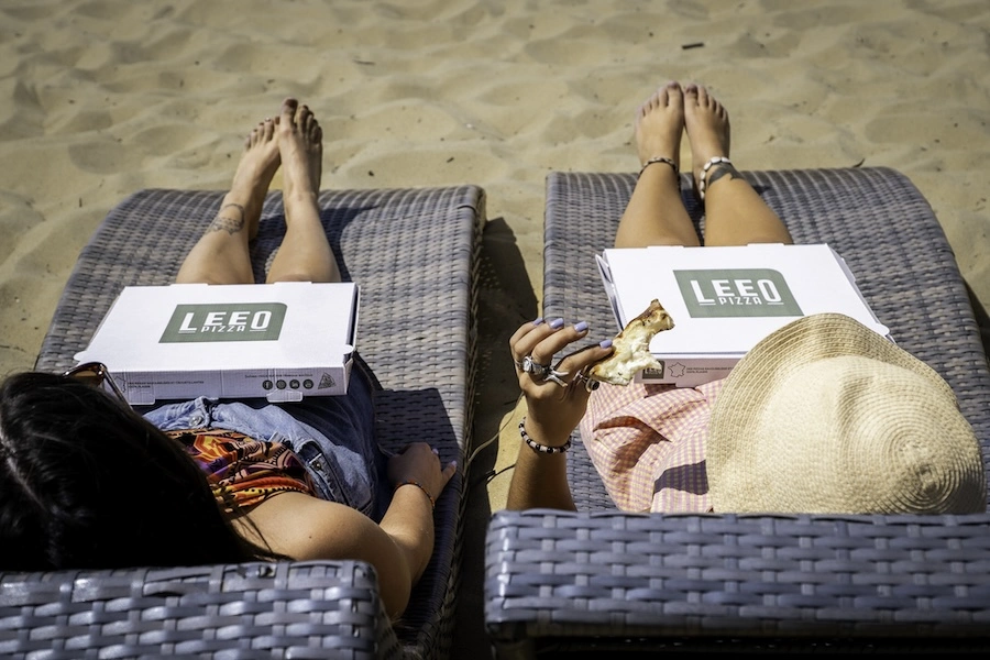 Deux vacancières en train de déguster une pizza artisanale achetée dans leur camping